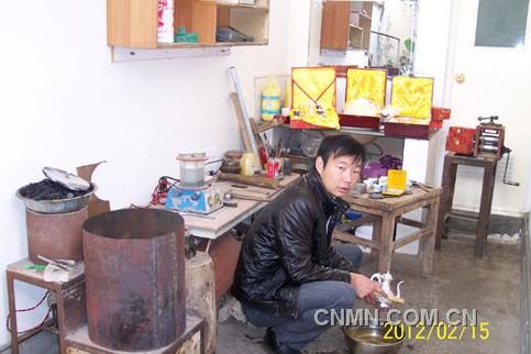 唐建安正在自家作坊内清洗刚錾完花的银制酒壶